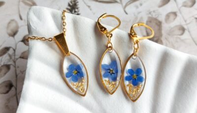 a set of earrings and necklaces with blue flowers